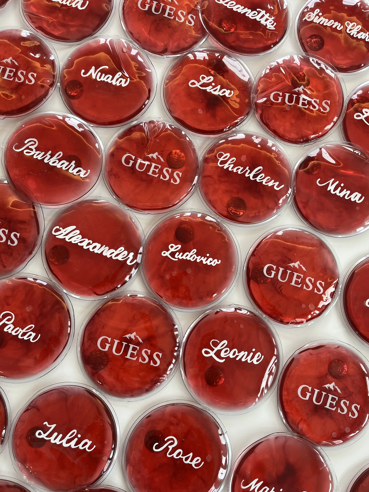 Rote GUESS-Handwärmer mit Namen in weisser Kalligrafie