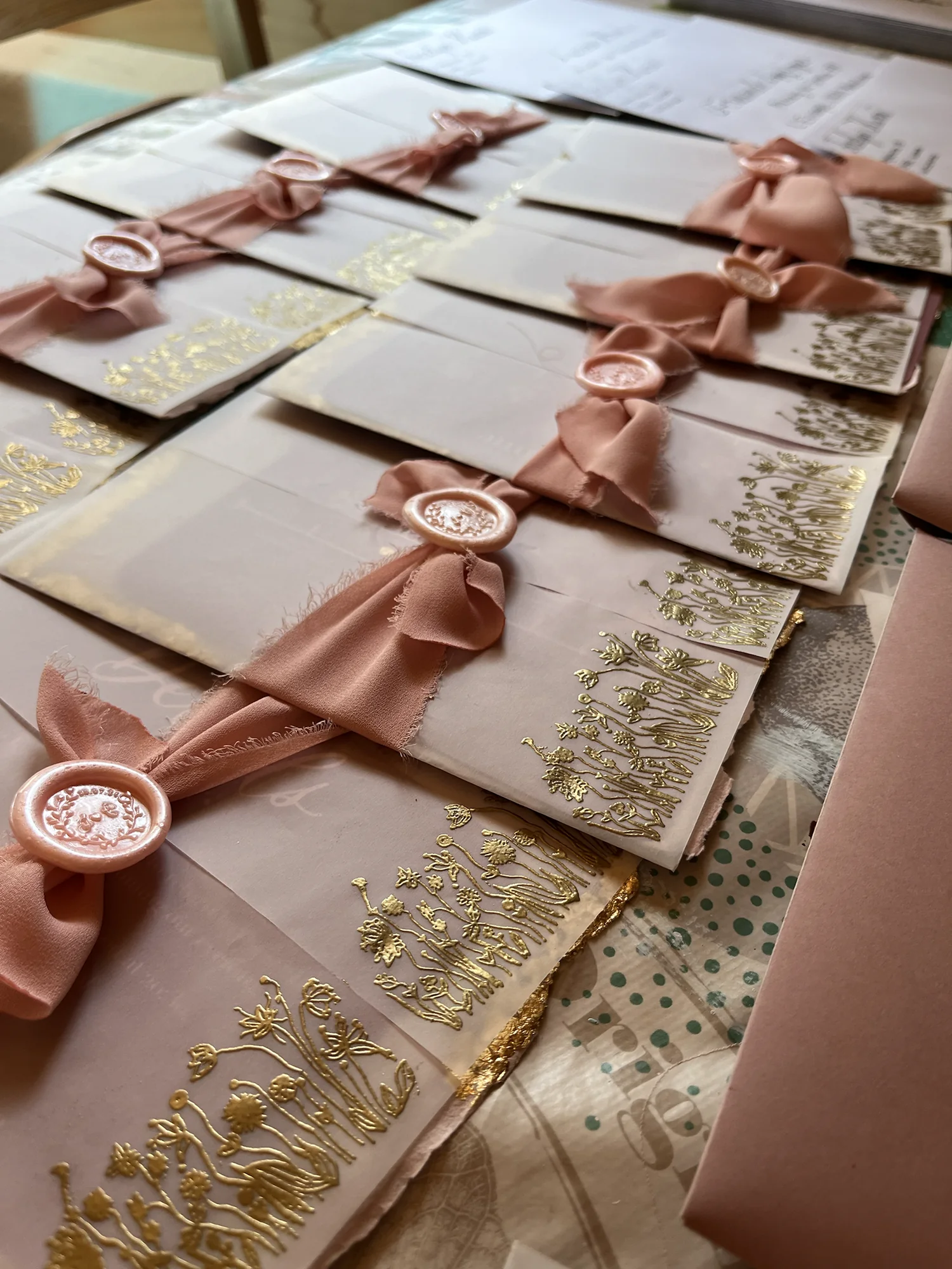 Roséfarbene handbeschriftete Couverts mit Seidenband, Wachssiegeln und goldenen Blütendetails