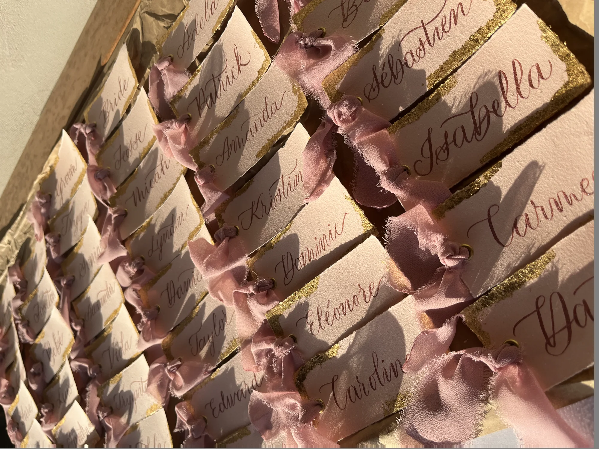 Handbeschriftete Platzkarten mit roséfarbenem Band