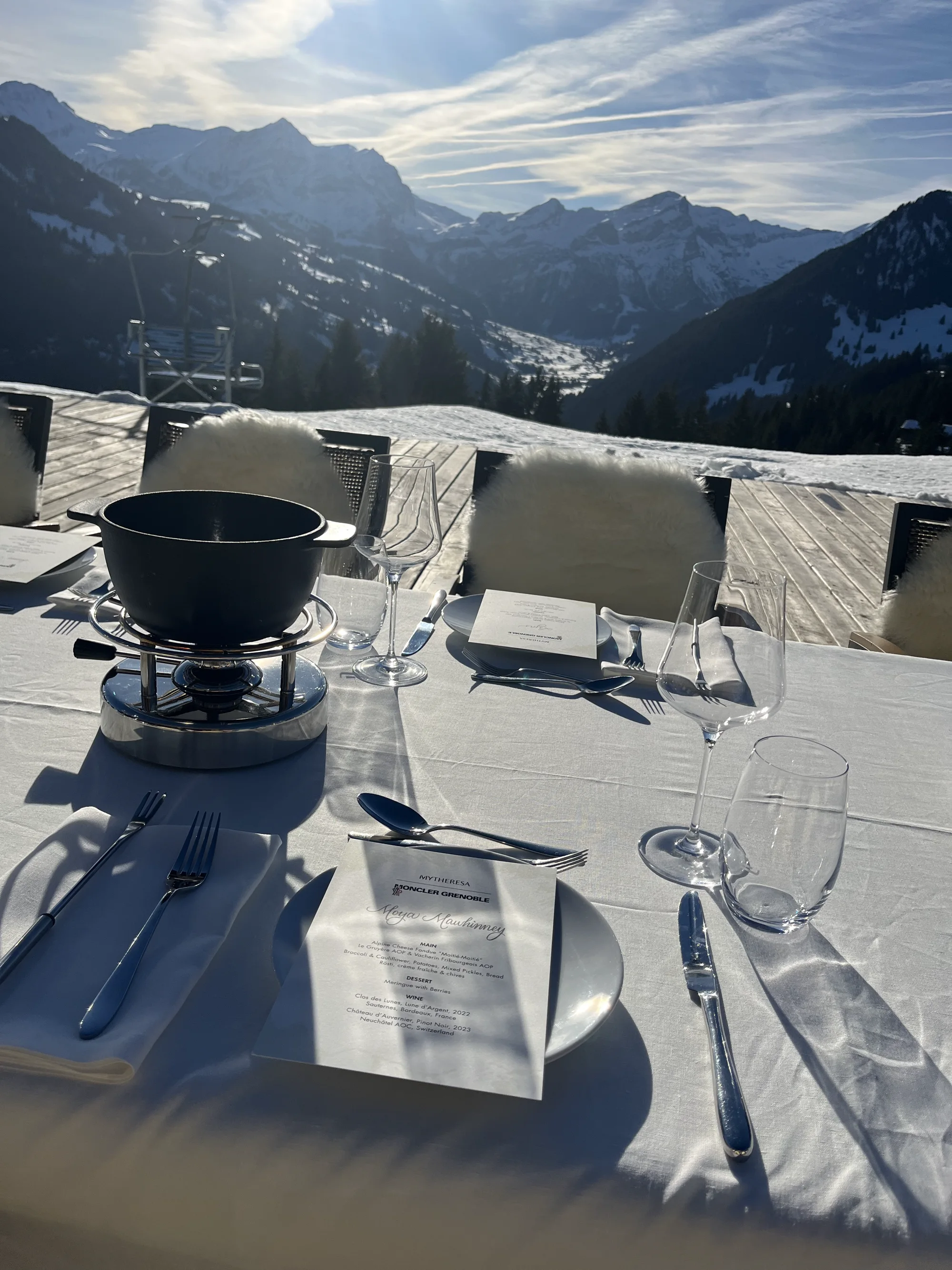 Hand-lettered fondue menu at a sunlit table overlooking the mountains from Eggli